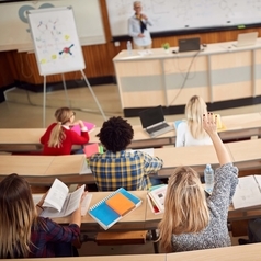 Studentinnen und Studenten sitzen während einer Vorlesung in einem Hörsaal.