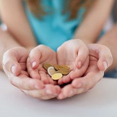 Hände eines Erwachsenen und eines Kindes halten Münzen.