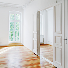 Eine helle, lichtdurchflutete Altbauwohnung mit einer großen Doppeltür ins andere Zimmer.