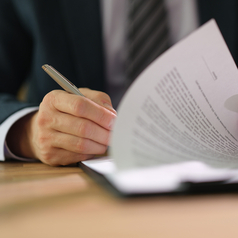 Erhebung der Tarifinformation: Ein Mann unterzeichnet einen Vertrag.