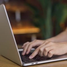 Eine Frau tippt auf einem Laptop.