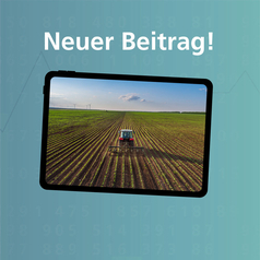 Auf einem Bildschirm ist ein Traktor auf einem Feld zu sehen.