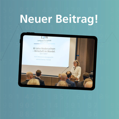 Jahrestagung LSN 2026: Auf einem Bildschirm ist im Vordergrund ein Saal-Publikum zu sehen, im Hintergrund die LSN-Präsidentin am Rednerpult.